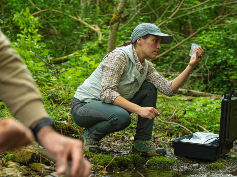 Scientist collecting a water sample in a test tube